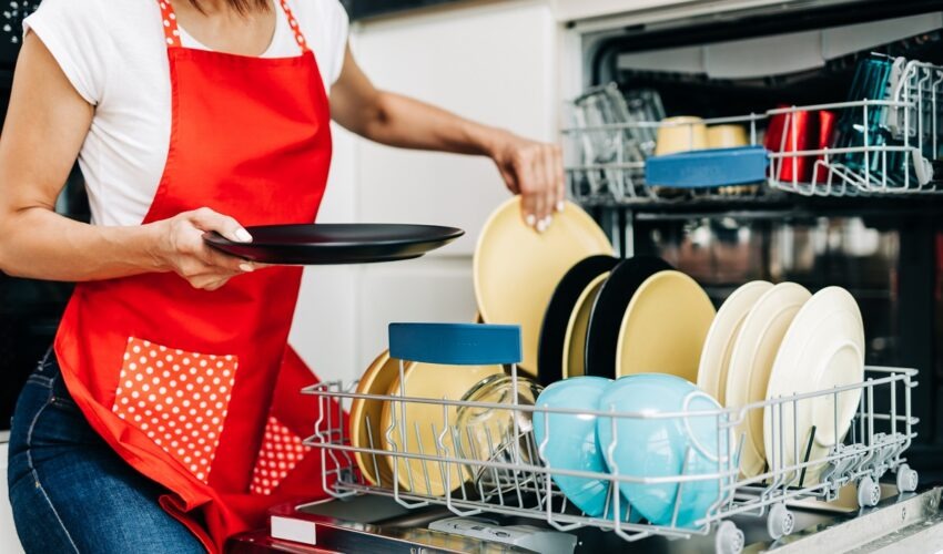 woman taking out clean dishes from dishwasher
